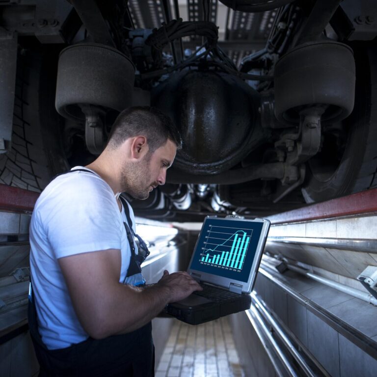 Technicien analysant les indicateurs de maintenance d’un véhicule sur GMAO portable